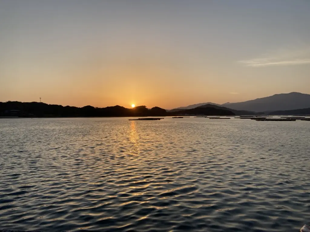 夕日が山の向こうに沈む海岸